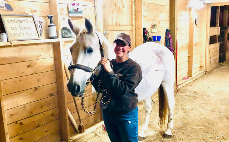 Jessie with horse in barn