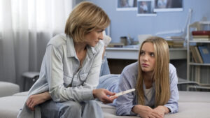 Image of mother and daughter with home pregnancy test.